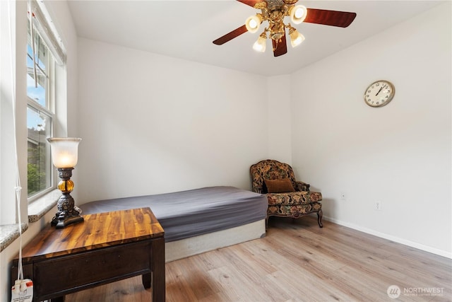 bedroom with light wood-type flooring, baseboards, and ceiling fan