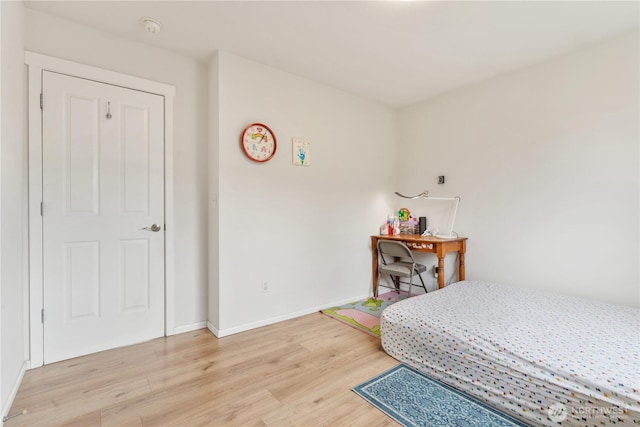 bedroom with light wood-style floors and baseboards
