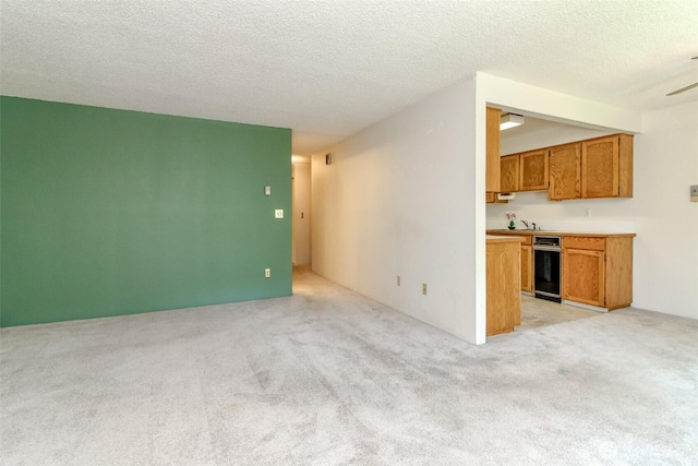 7308 N Skyview Ln Unit I-204, Tacoma, WA 98406 - unfurnished living room with light colored carpet, a textured ceiling, and ceiling fan