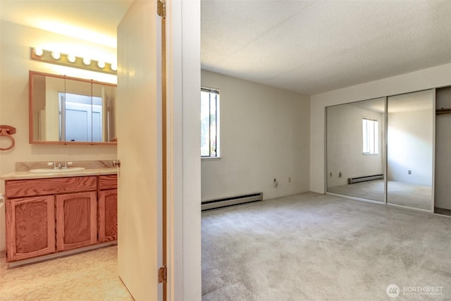 7308 N Skyview Ln Unit I-204, Tacoma, WA 98406 - unfurnished bedroom featuring a baseboard heating unit, a baseboard radiator, a sink, light colored carpet, and a closet