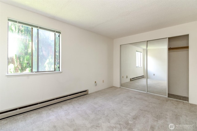 7308 N Skyview Ln Unit I-204, Tacoma, WA 98406 - unfurnished bedroom with baseboard heating, carpet floors, a closet, and a textured ceiling