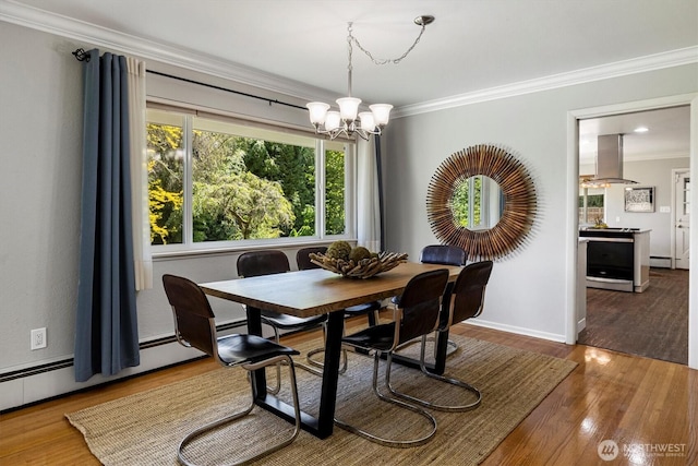 11411 Clovercrest Dr SW, Lakewood, WA 98499 - dining area with a chandelier, crown molding, wood finished floors, baseboards, and a baseboard heating unit