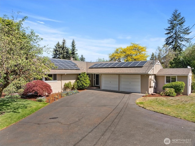 11411 Clovercrest Dr SW, Lakewood, WA 98499 - ranch-style house featuring a garage, driveway, roof mounted solar panels, a front yard, and a shingled roof