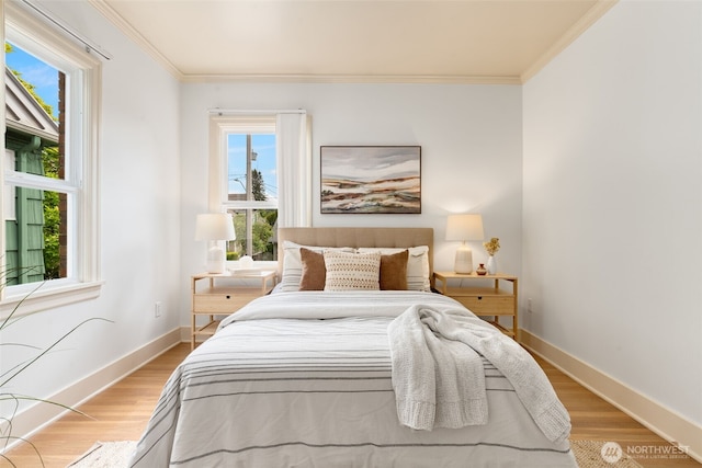 bedroom with crown molding, baseboards, and light wood-style flooring