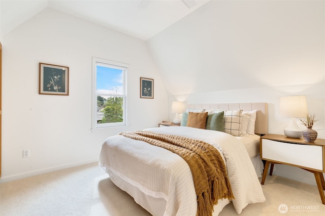 carpeted bedroom featuring lofted ceiling and baseboards