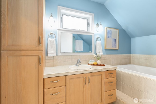full bathroom with lofted ceiling, vanity, and tiled bath