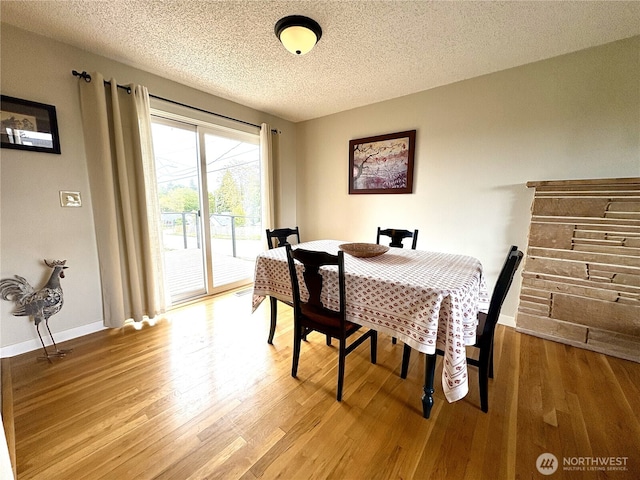 10644 19th Ave SW, Seattle, WA 98146 - dining area featuring wood finished floors, a textured ceiling, and baseboards