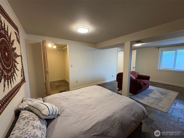 10644 19th Ave SW, Seattle, WA 98146 - bedroom with baseboards, dark stone finish floors, and a walk in closet