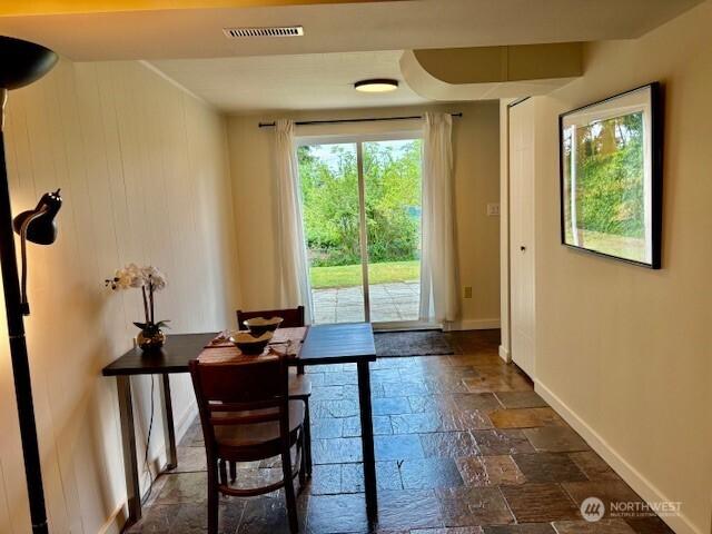 10644 19th Ave SW, Seattle, WA 98146 - doorway to outside featuring stone tile floors, healthy amount of natural light, and baseboards