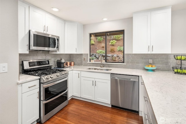 6700 81st Ave SE, Mercer Island, WA 98040 - kitchen with appliances with stainless steel finishes, a sink, white cabinetry, light stone counters, and decorative backsplash