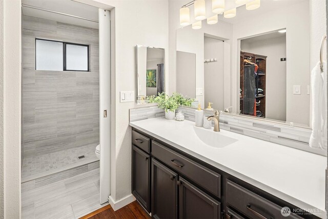 6700 81st Ave SE, Mercer Island, WA 98040 - full bathroom featuring toilet, vanity, a tile shower, and a spacious closet
