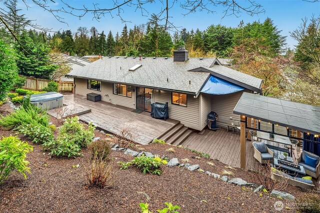 6700 81st Ave SE, Mercer Island, WA 98040 - back of house featuring a hot tub, fence, a chimney, a deck, and roof with shingles