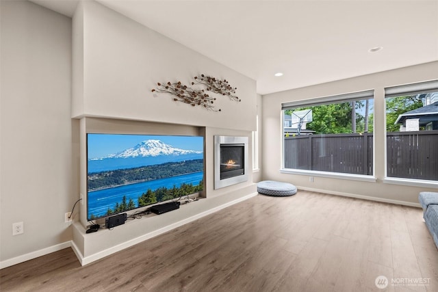 24821 237th Ln SE, Maple Valley, WA 98038 - unfurnished living room featuring wood finished floors, baseboards, a warm lit fireplace, and recessed lighting