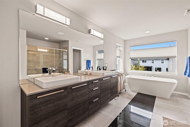 24821 237th Ln SE, Maple Valley, WA 98038 - full bathroom with double vanity, a shower stall, a freestanding tub, baseboards, and tile patterned flooring