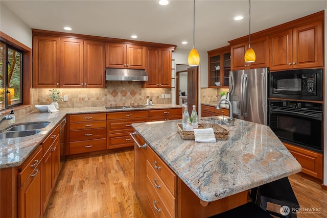 5310 W Mercer Way, Mercer Island, WA 98040 - kitchen featuring black appliances, under cabinet range hood, brown cabinetry, a sink, and recessed lighting
