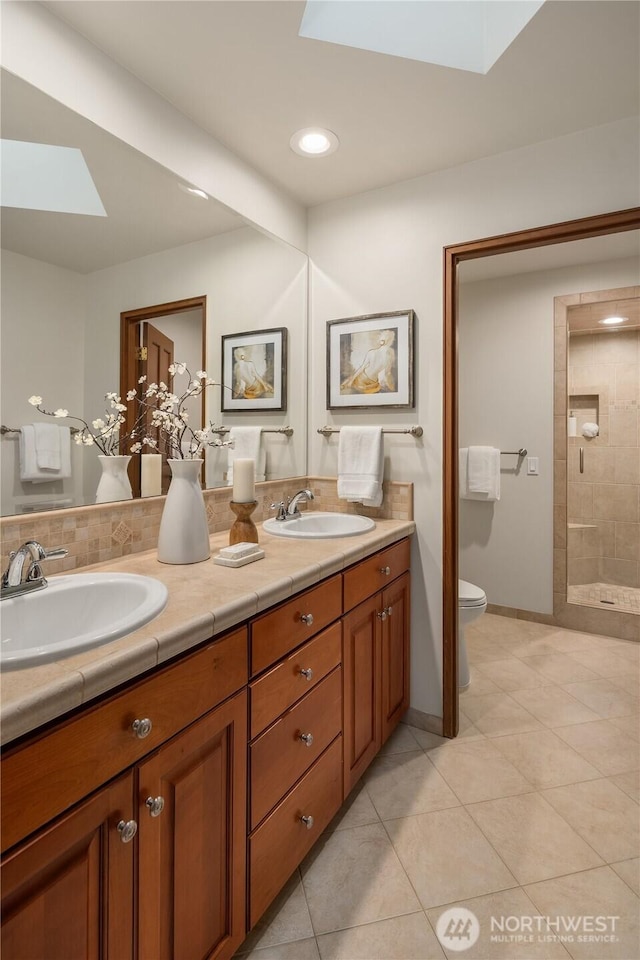 5310 W Mercer Way, Mercer Island, WA 98040 - bathroom featuring a skylight, tile patterned flooring, double vanity, toilet, and recessed lighting
