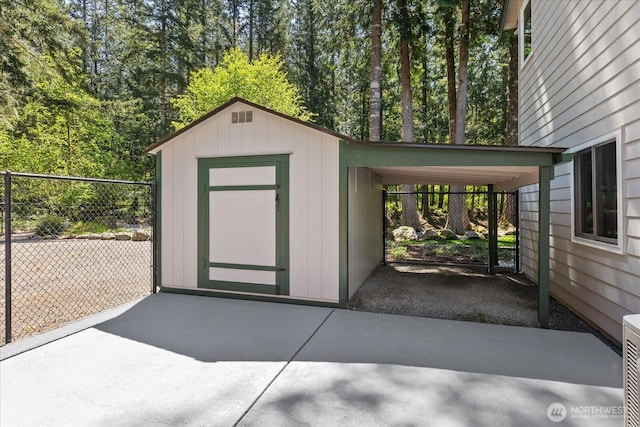 view of shed with fence and a carport