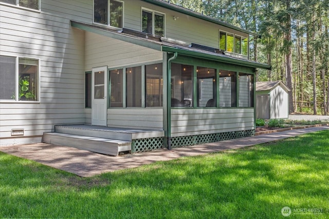 rear view of house featuring a sunroom, a yard, a shed, and an outdoor structure