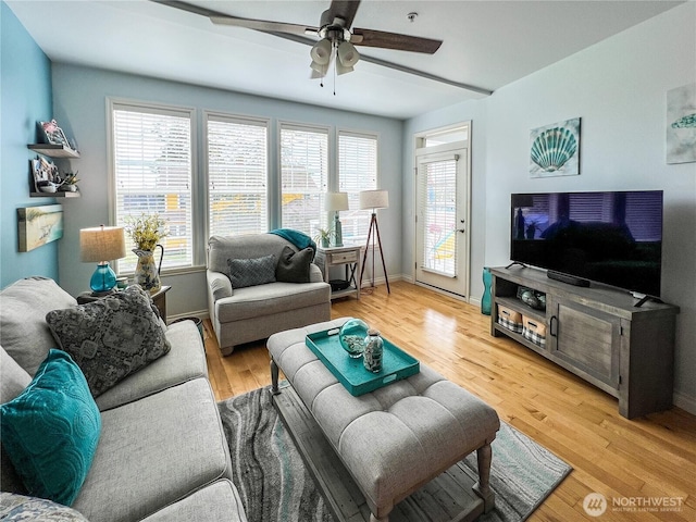 living room with ceiling fan, light wood finished floors, and baseboards