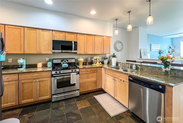 kitchen with stainless steel appliances, a sink, a peninsula, stone counters, and recessed lighting