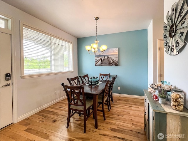 dining area with light wood finished floors, a chandelier, and baseboards