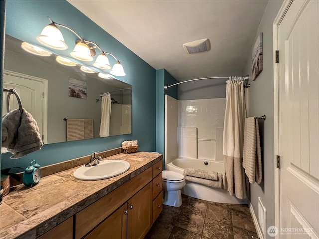 bathroom featuring toilet, stone finish floors, shower / bath combination with curtain, and vanity