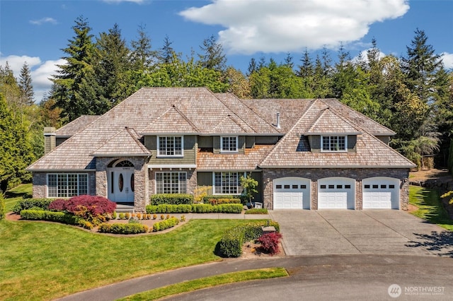 view of front of home with driveway, a front yard, stone siding, and a chimney