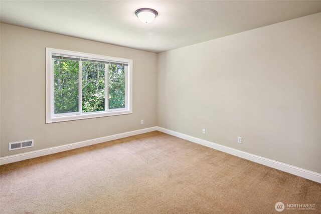 spare room featuring baseboards and carpet