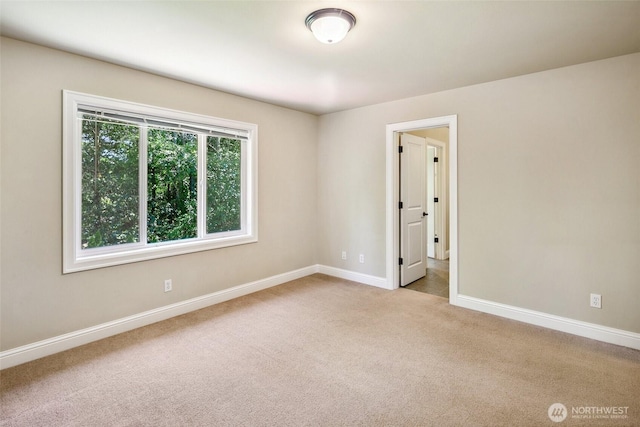 unfurnished room featuring carpet and baseboards
