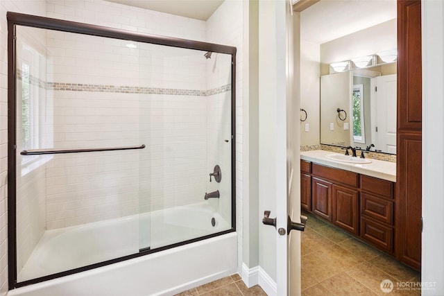 full bathroom with vanity, shower / bath combination with glass door, tile patterned floors, and baseboards
