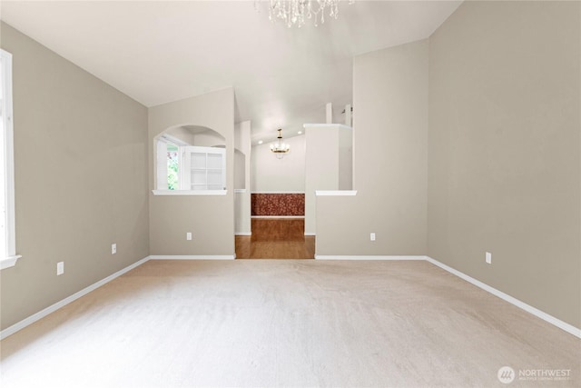 2222 60th Ln NW, Olympia, WA 98502 - carpeted spare room featuring a chandelier, baseboards, and arched walkways