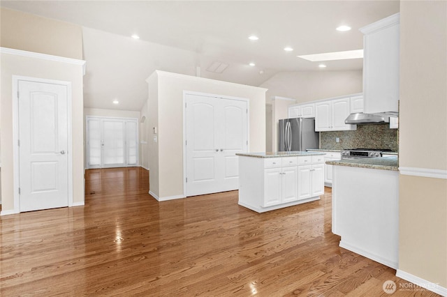 2222 60th Ln NW, Olympia, WA 98502 - kitchen with stainless steel appliances, lofted ceiling, a kitchen island, white cabinets, and tasteful backsplash