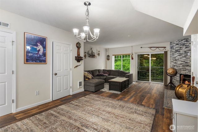 living room with wood finished floors, a chandelier, baseboards, and a large fireplace