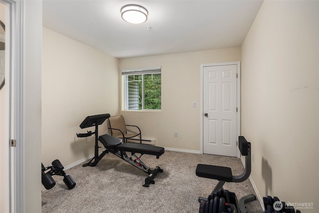 exercise area with carpet flooring, baseboards, and a baseboard heating unit
