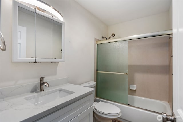 full bath featuring toilet, combined bath / shower with glass door, and vanity