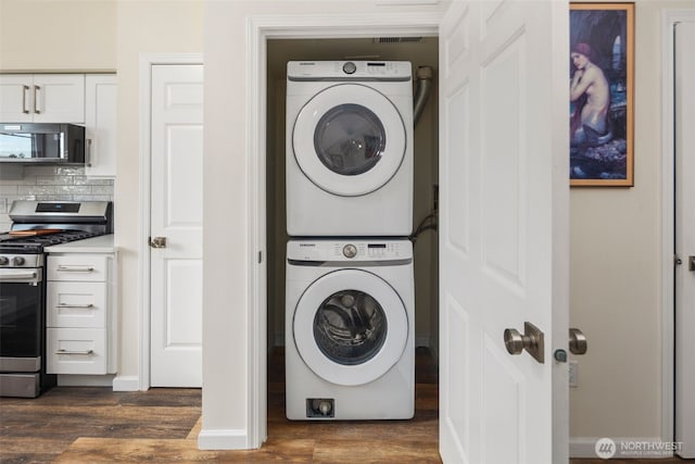 washroom with estacked washer and dryer and dark wood finished floors