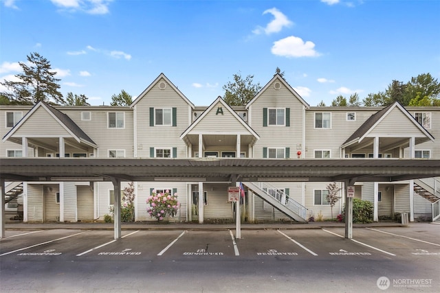 view of building exterior featuring stairway and covered parking