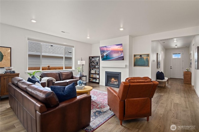 12713 176th Ave E, Bonney Lake, WA 98391 - living room with light wood-type flooring, a warm lit fireplace, and recessed lighting