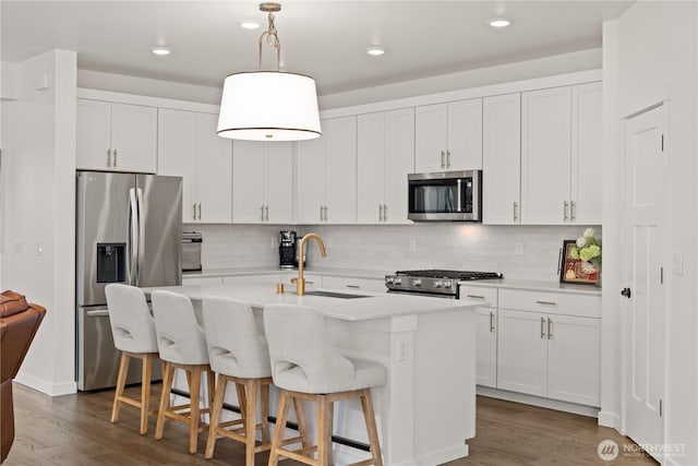 12713 176th Ave E, Bonney Lake, WA 98391 - kitchen featuring appliances with stainless steel finishes, wood finished floors, a kitchen island with sink, tasteful backsplash, and recessed lighting
