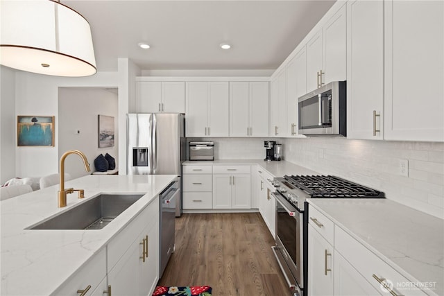 12713 176th Ave E, Bonney Lake, WA 98391 - kitchen with appliances with stainless steel finishes, white cabinetry, tasteful backsplash, wood finished floors, and recessed lighting