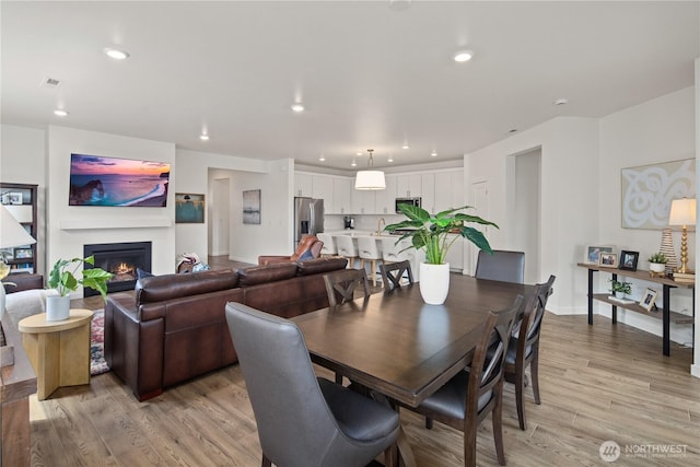 12713 176th Ave E, Bonney Lake, WA 98391 - dining area with light wood-style floors, recessed lighting, and a glass covered fireplace