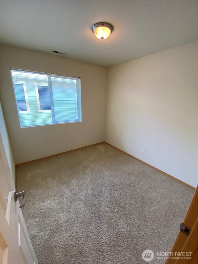 carpeted empty room with baseboards