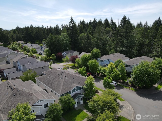 aerial view of residential area featuring a forest