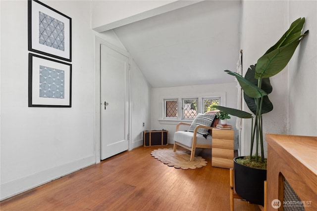sitting room featuring vaulted ceiling, wood finished floors, and baseboards