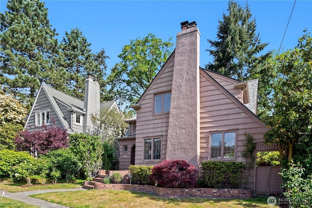 view of home's exterior featuring a chimney and a yard
