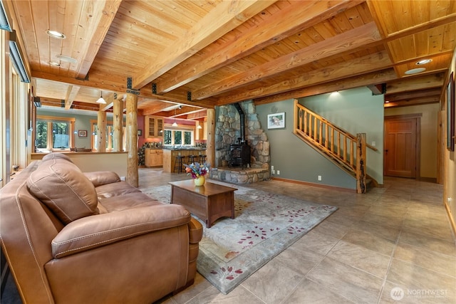 living area featuring stairway, plenty of natural light, wooden ceiling, beam ceiling, and baseboards