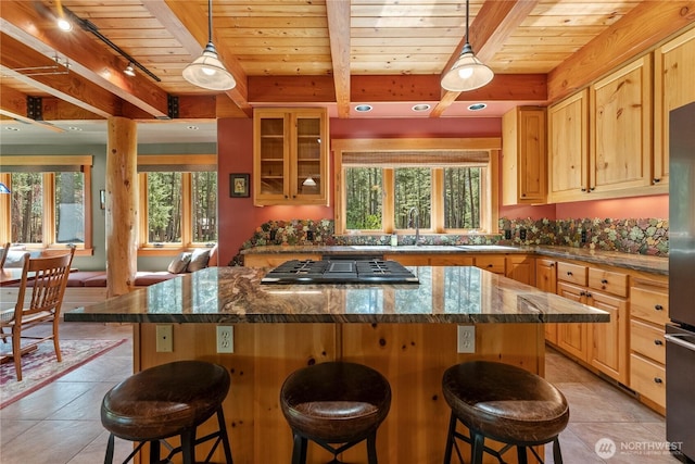 kitchen featuring a sink, plenty of natural light, wooden ceiling, gas cooktop, and a center island