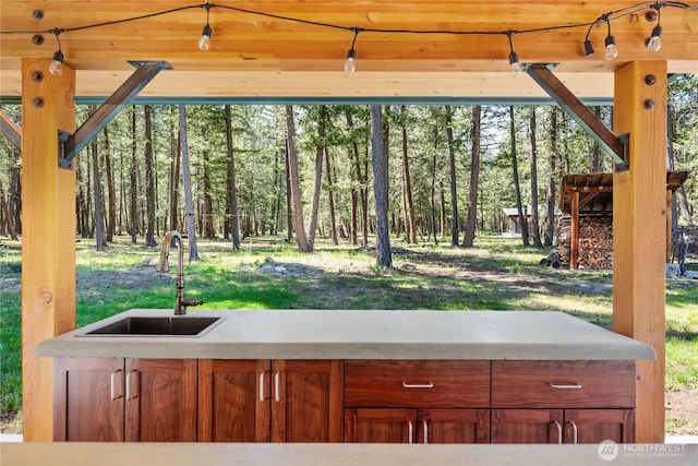 view of patio / terrace with a sink and a view of trees