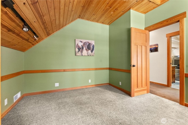 empty room with wood ceiling, vaulted ceiling, carpet flooring, and baseboards