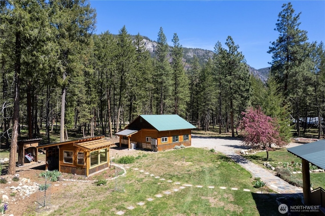 view of subject property featuring a forest and mountains